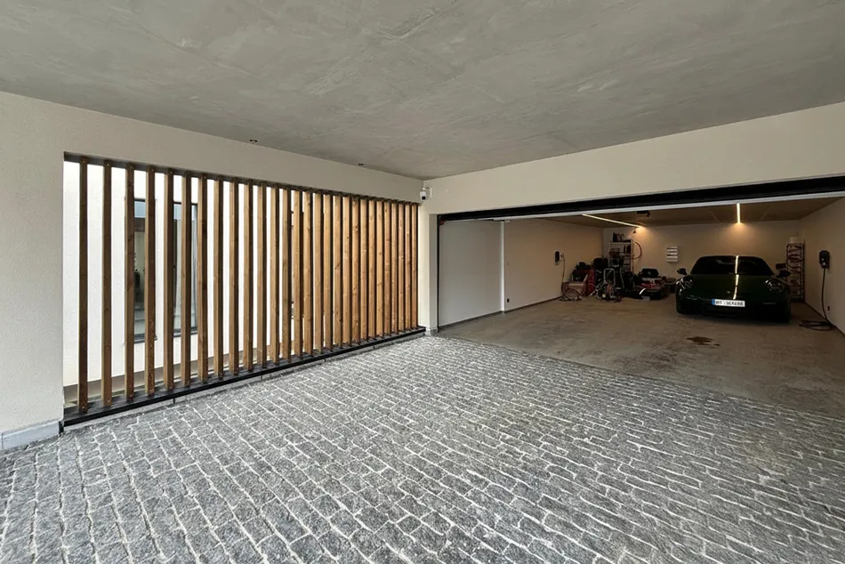 Garage tasseaux de bois et pavés anciens d'une maison en béton