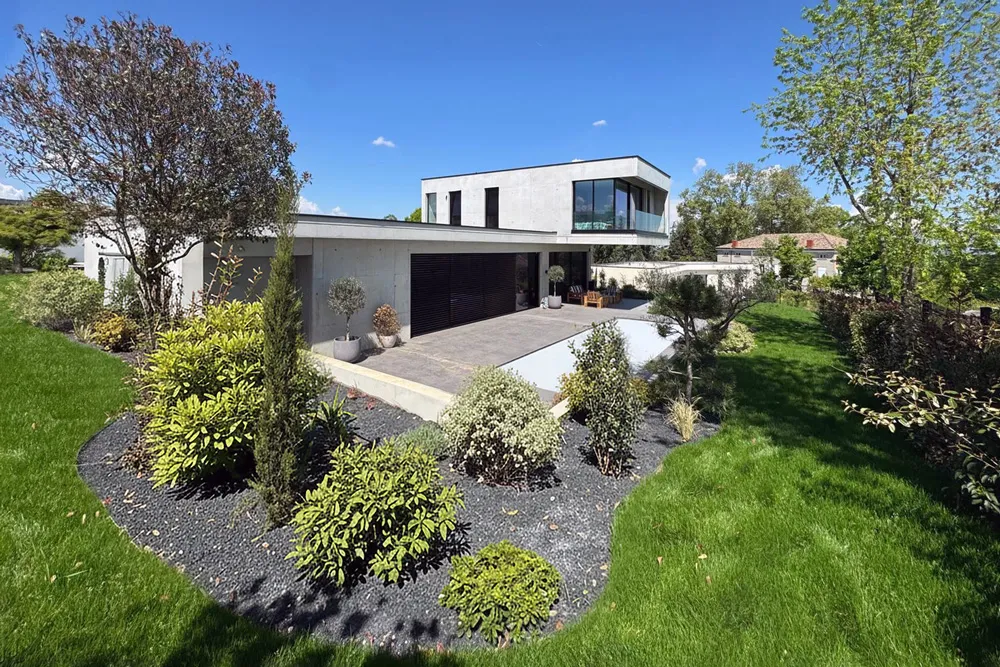 Vue d'ensemble d'une maison contemporaine d'architecte en béton dans son environnement végétal