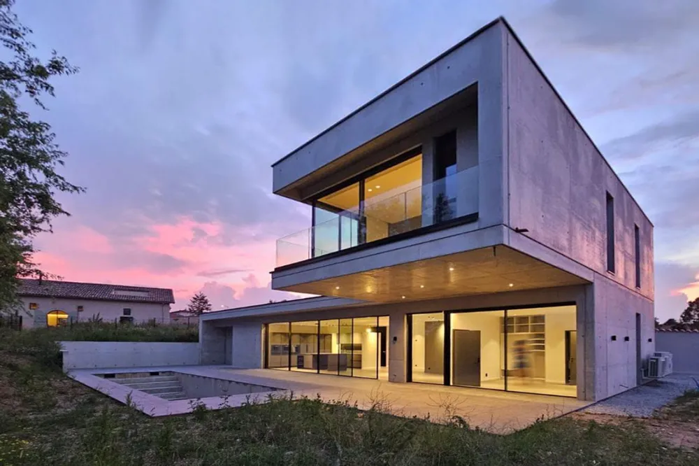 Porte-à-faux d'une maison en contemporaine en béton apparent au crépuscule